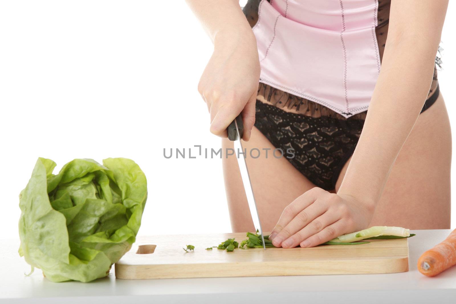 Sexy woman preparing healthy food salad with green vegetable and knife