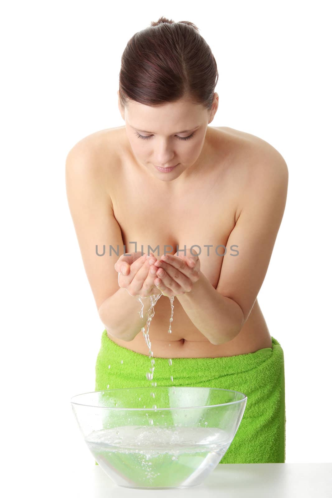 Beautiful young woman with hands in water, isolated on white