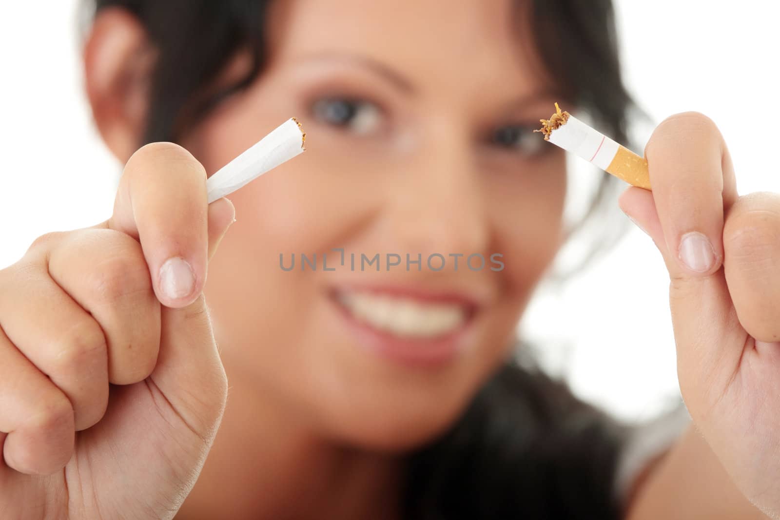 Young woman quiting smoking, isolated on white - focus on hand