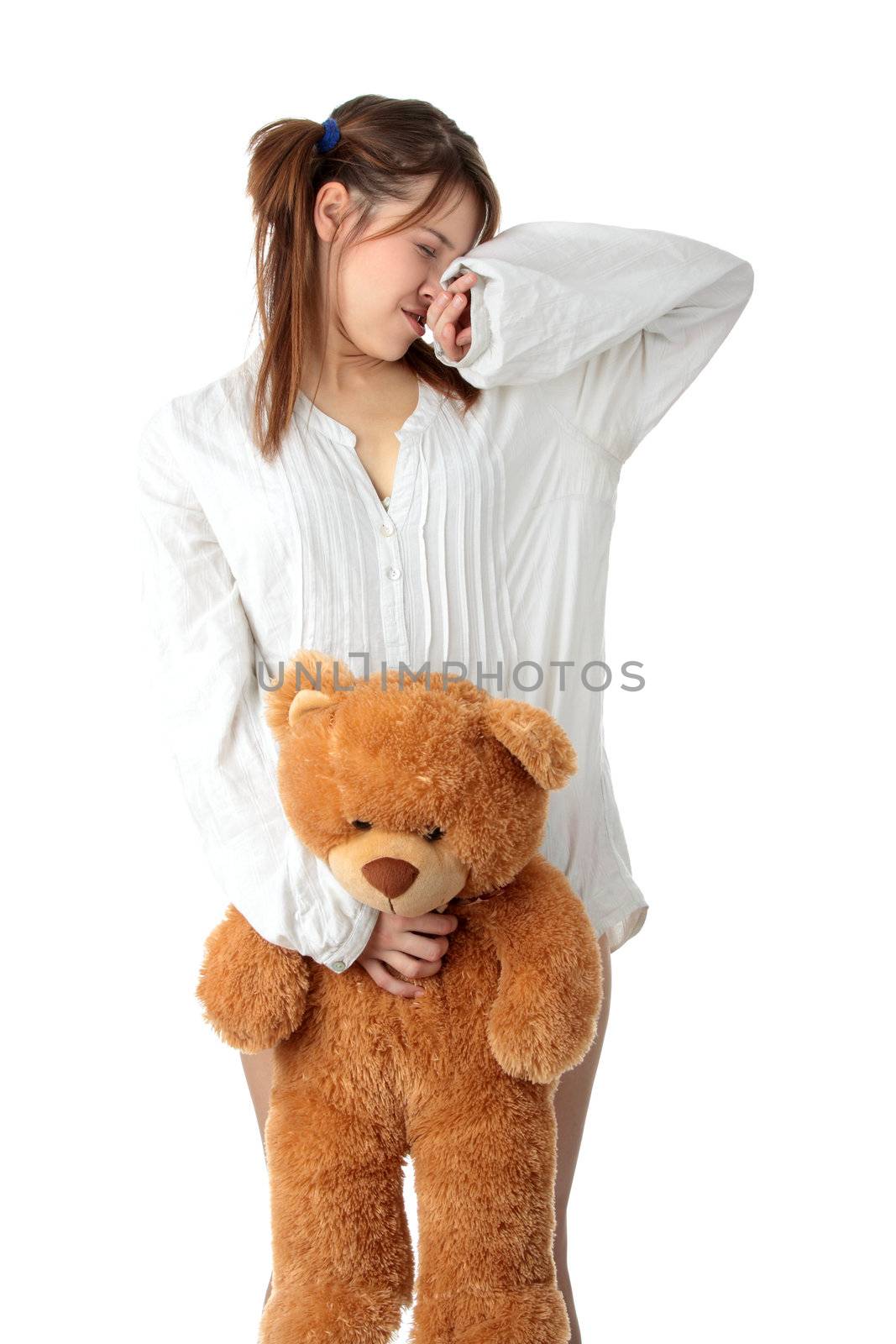 Young beautiful teen woman in long shirt with her teddy bear, isolated on white background