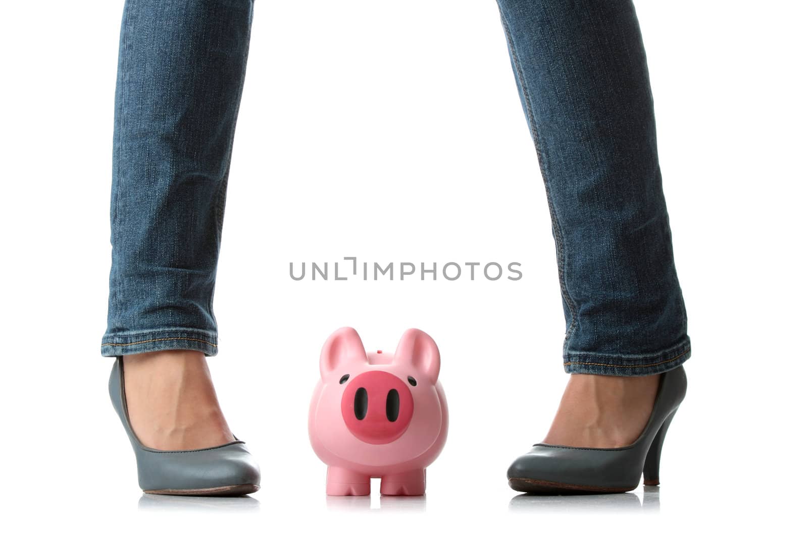 Young woman about to smash piggy bank with her legto get at savings