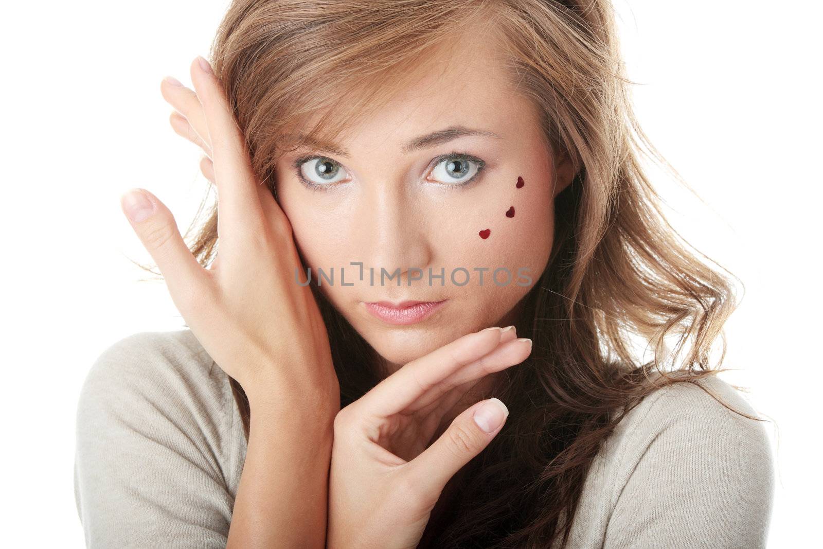 Young caucasian woman with light make up and hearts on face isolated on white background