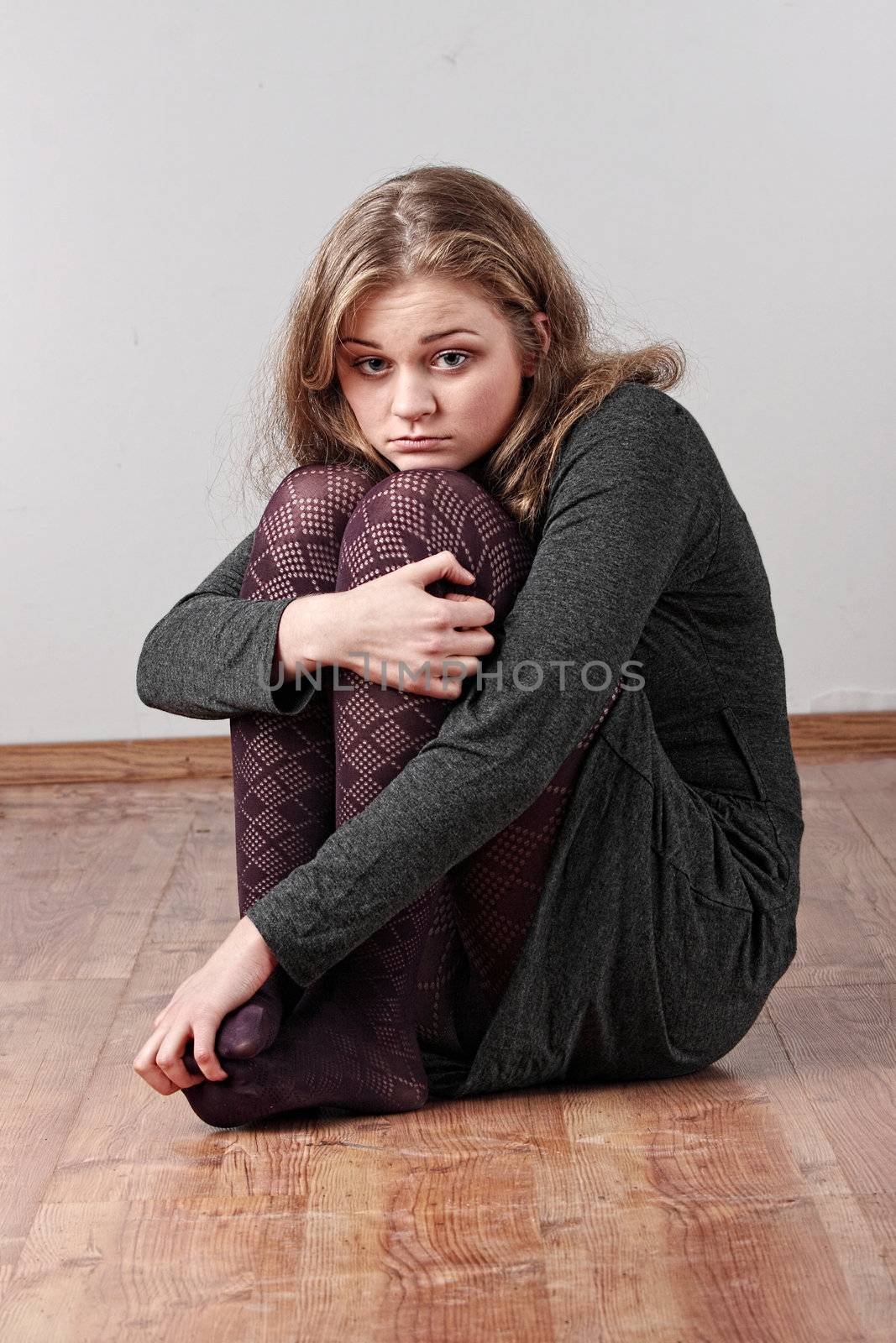 Sad or depressed woman sitting on the flor