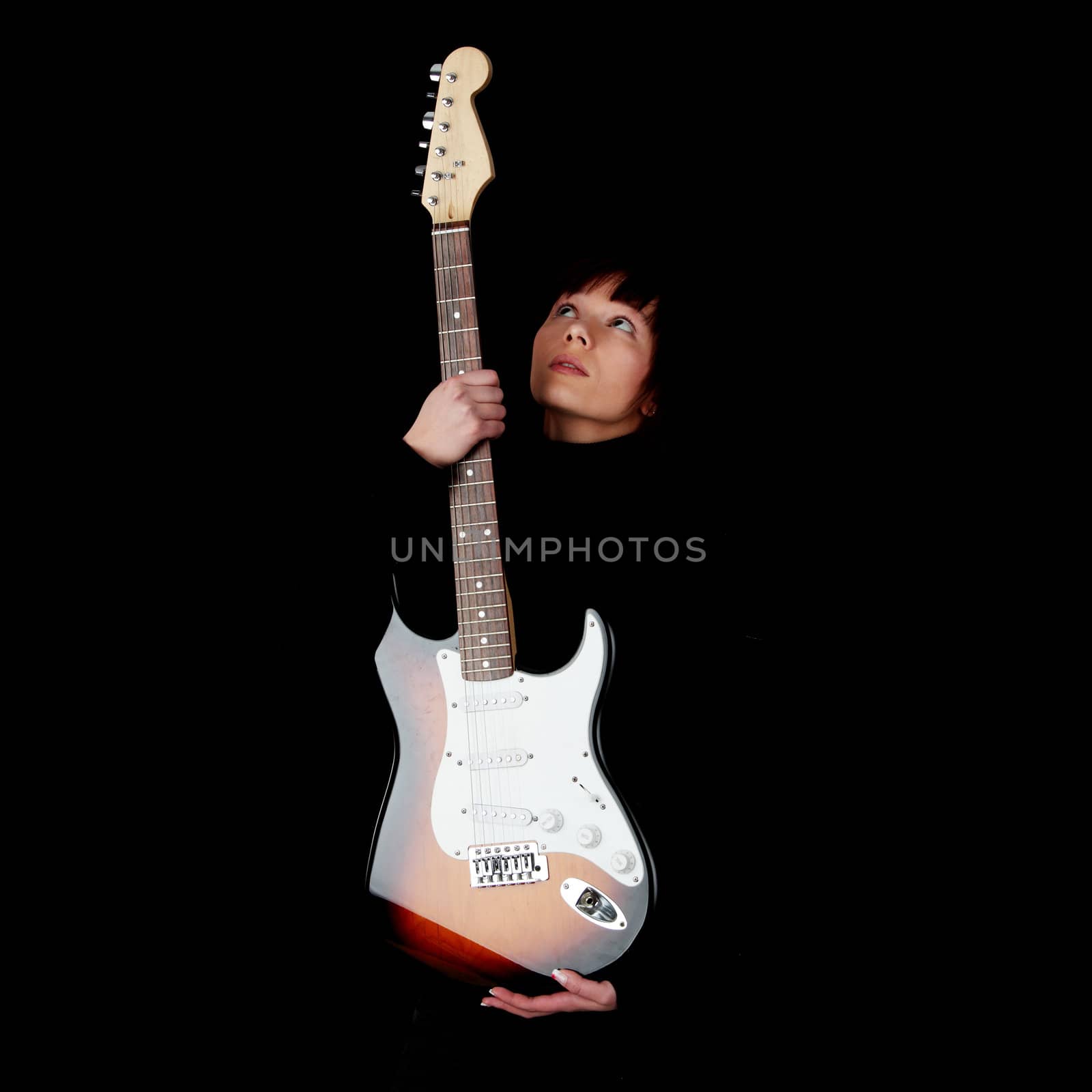 Woman with electric guitar, over black background