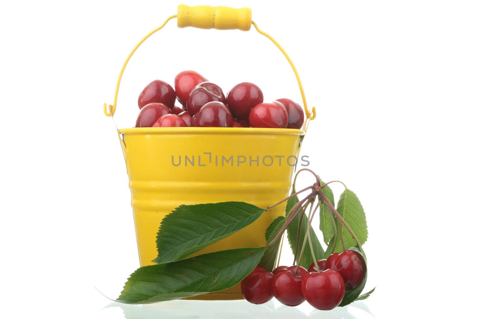 Cherries in colorful yellow metal bucket by BDS