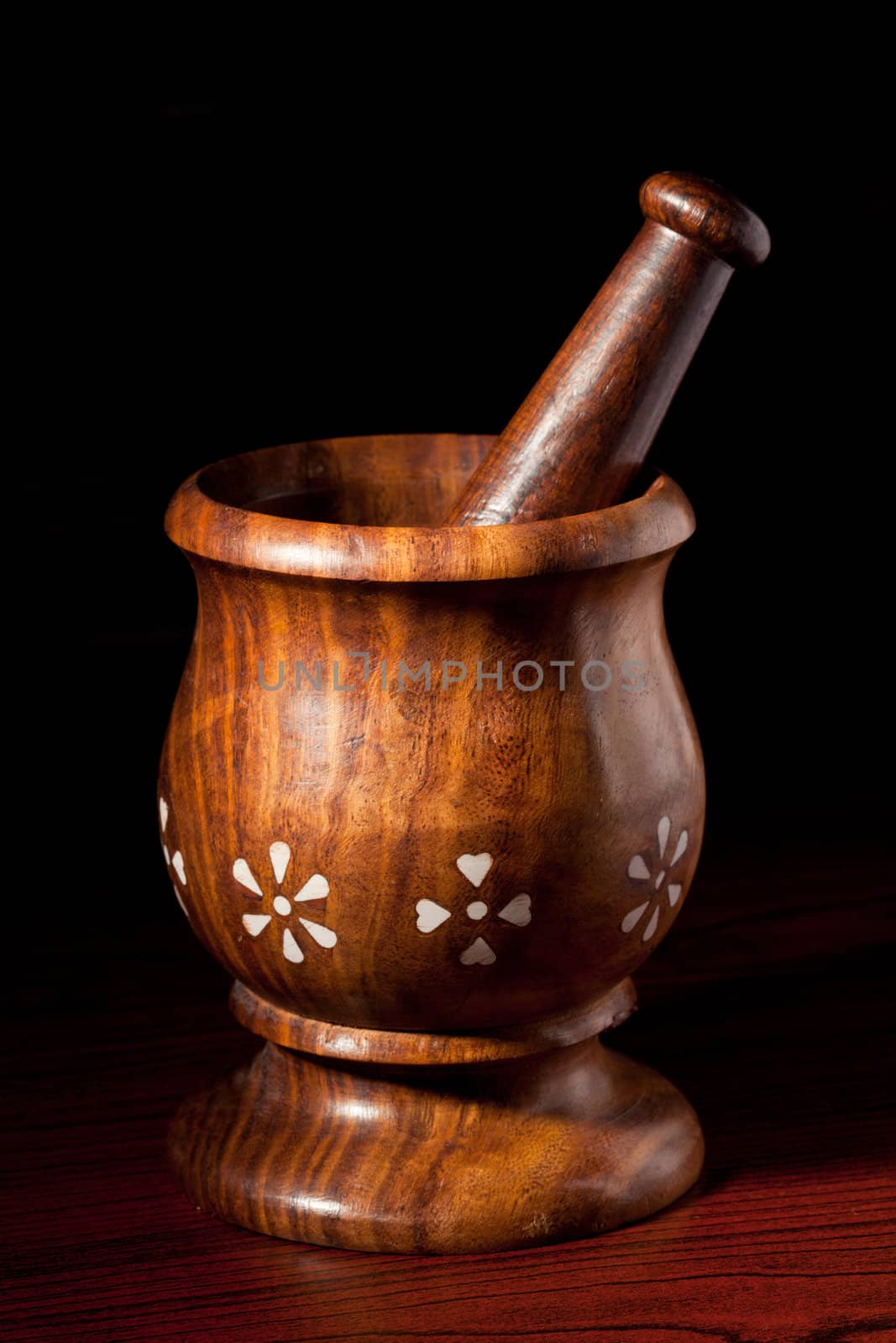 Wooden mortar and pestle on dark by dimol