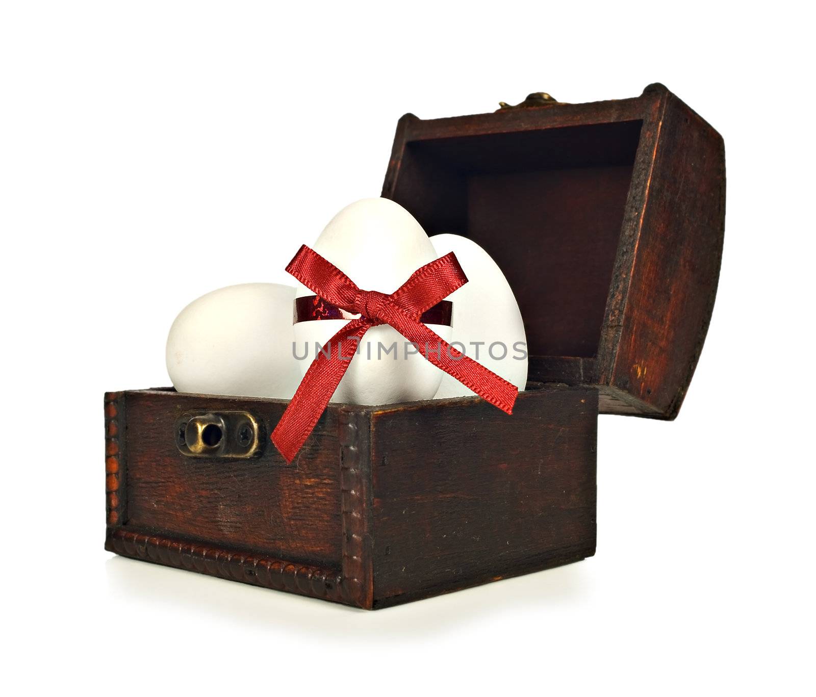 White candy easter eggs in a chest on a white background
