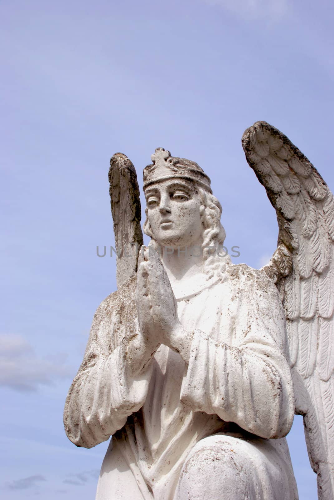 Sculpture of white angel praying by sauletas