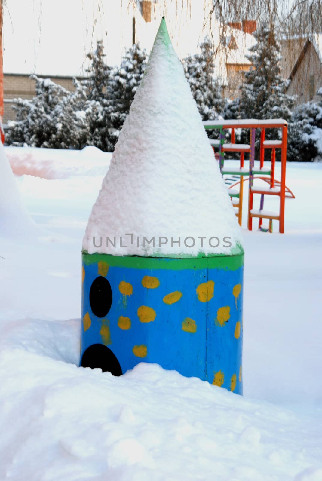 Empty playground near kindergaten covered by snow in cold winter