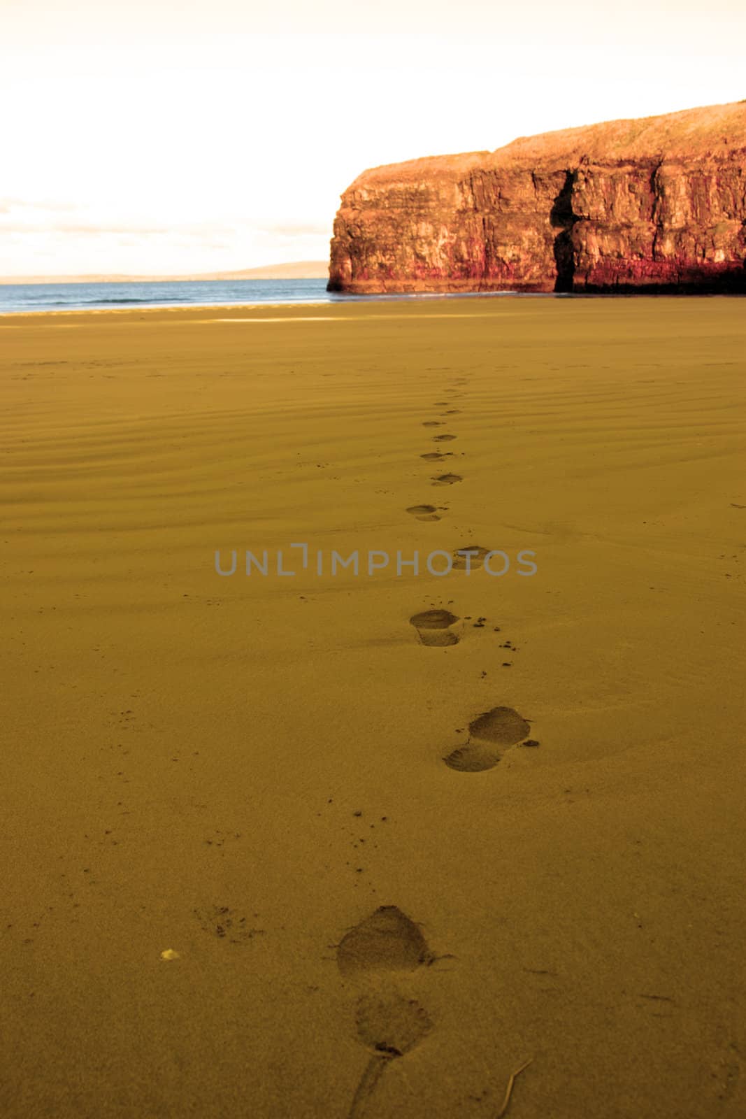 footprints on an empty beach on a beautiful winters day
