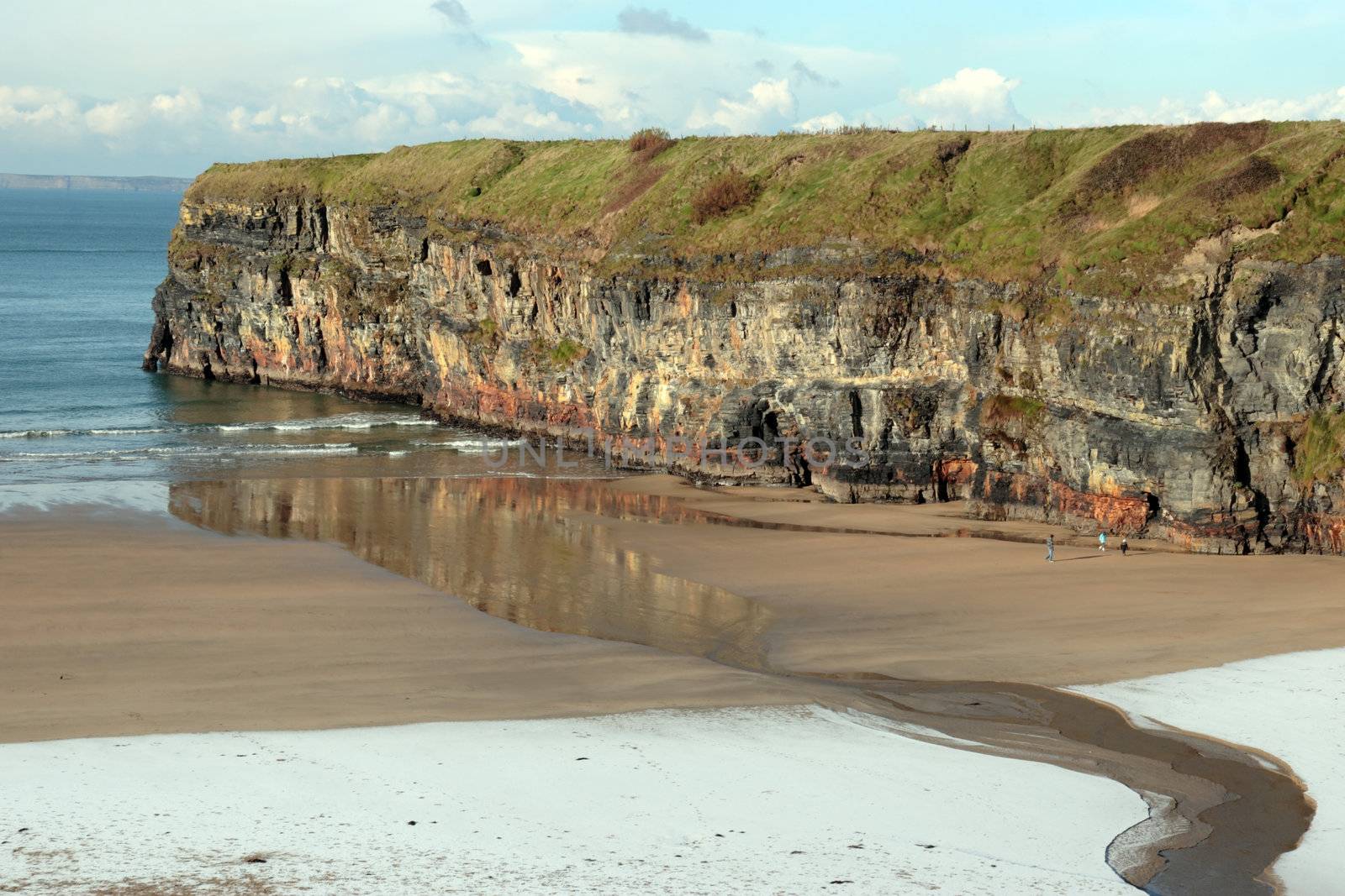 tourists on an empty rocky beach on a cold freezing winters day