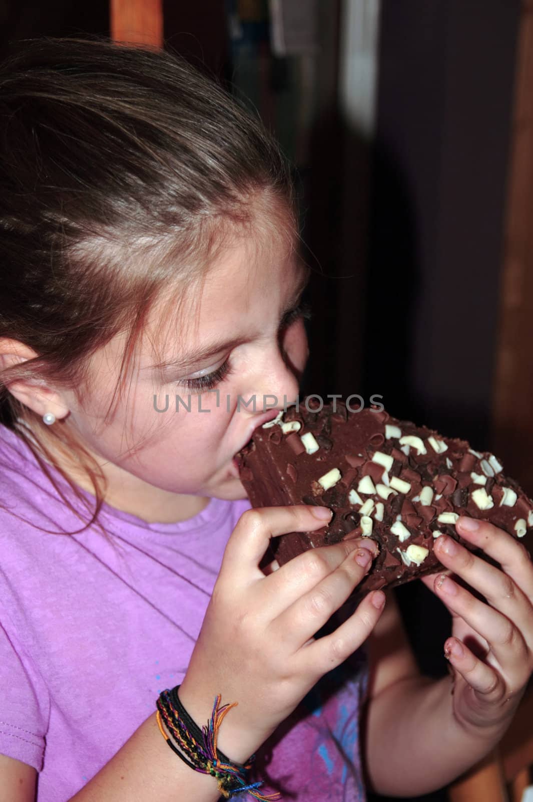 young girl enjoying a taste of chocolate cake