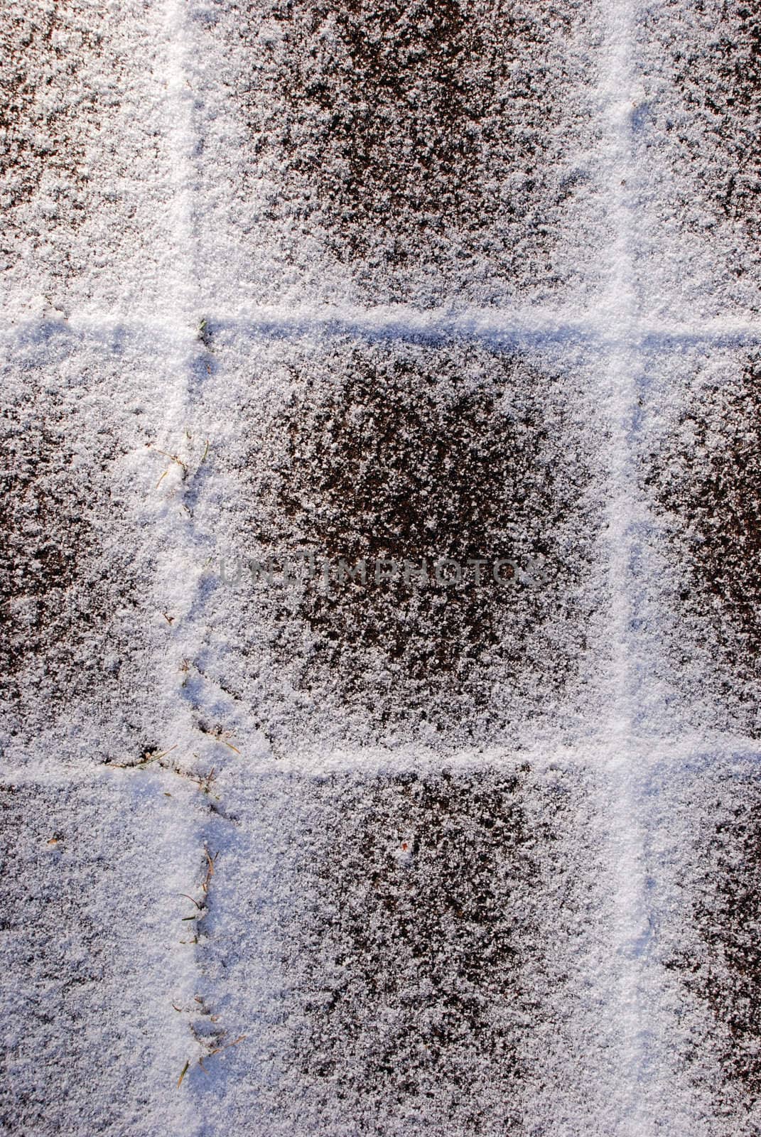 Snow falls on the snow-covered tile in winter.