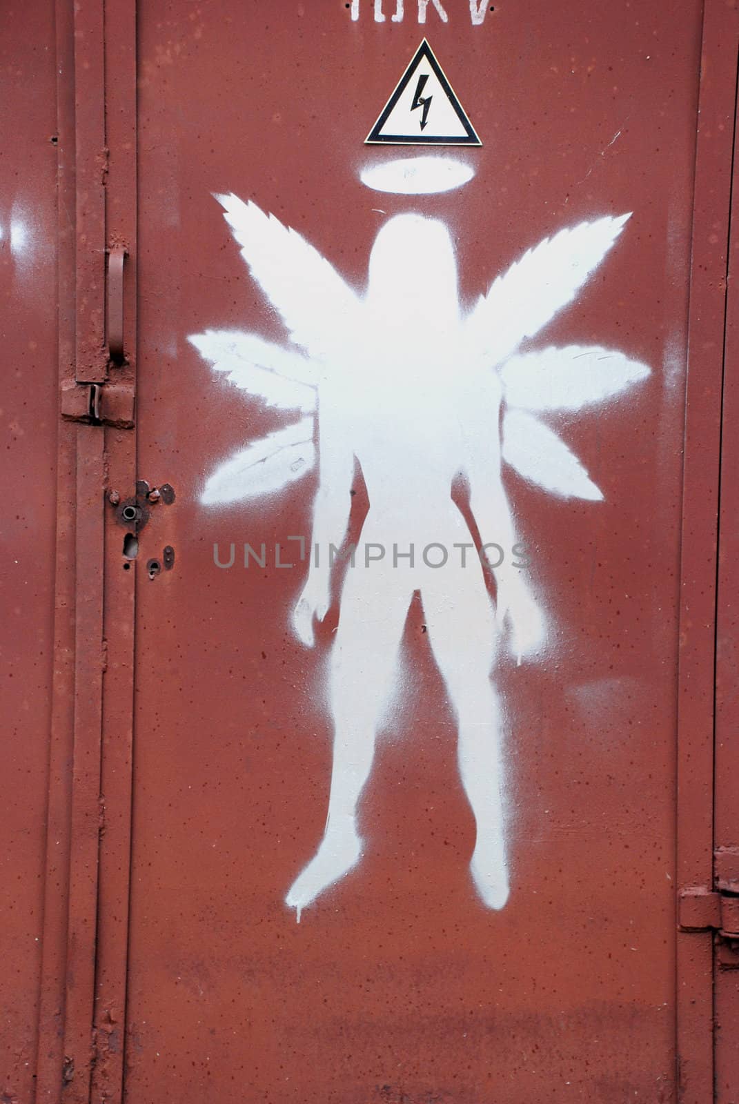 Graffiti figure with six wing painted on metal door of electric substation.