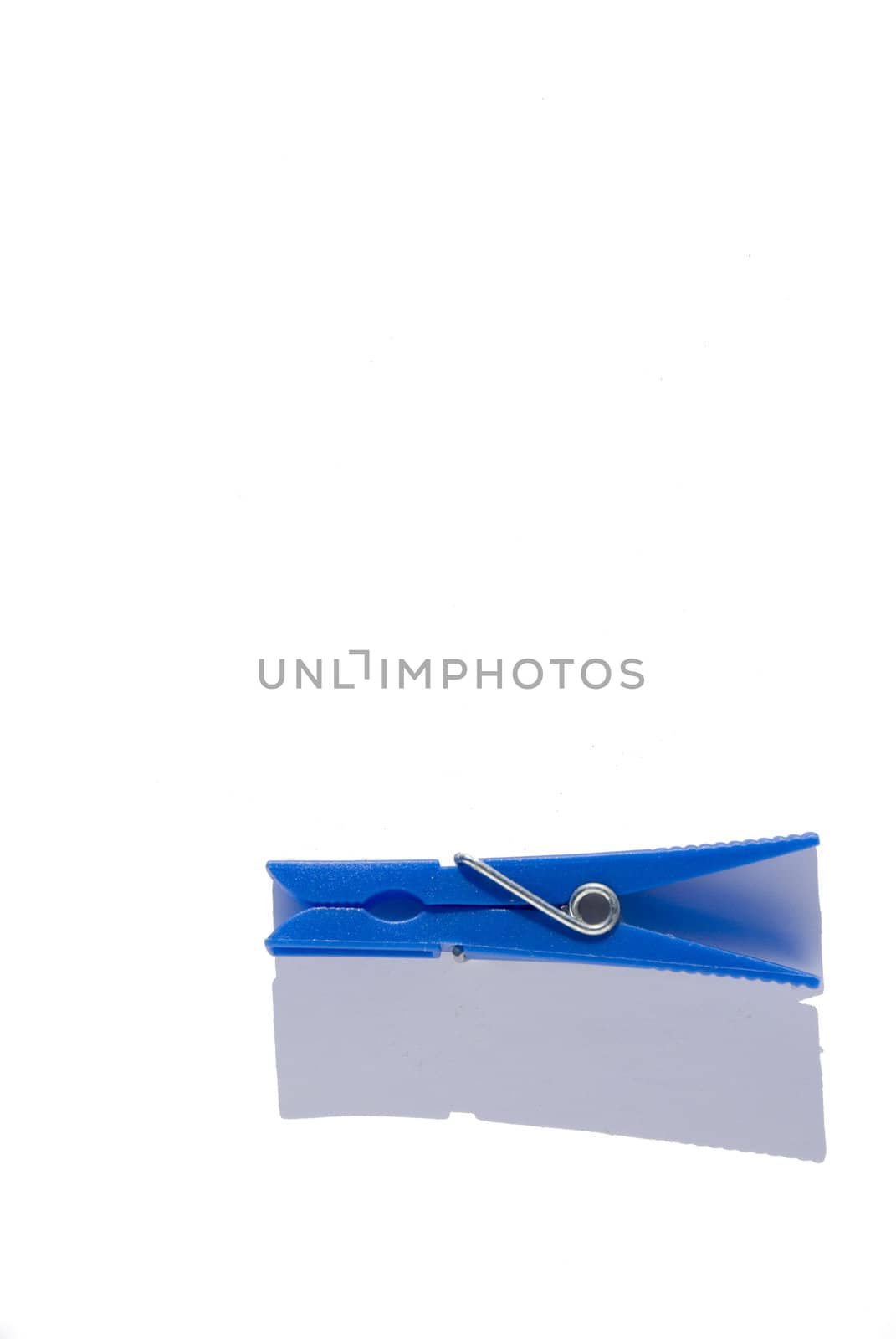 Blue clothes pin on a white background