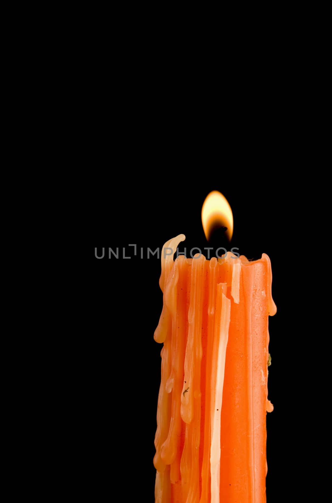 Orange candle burning in the dark background