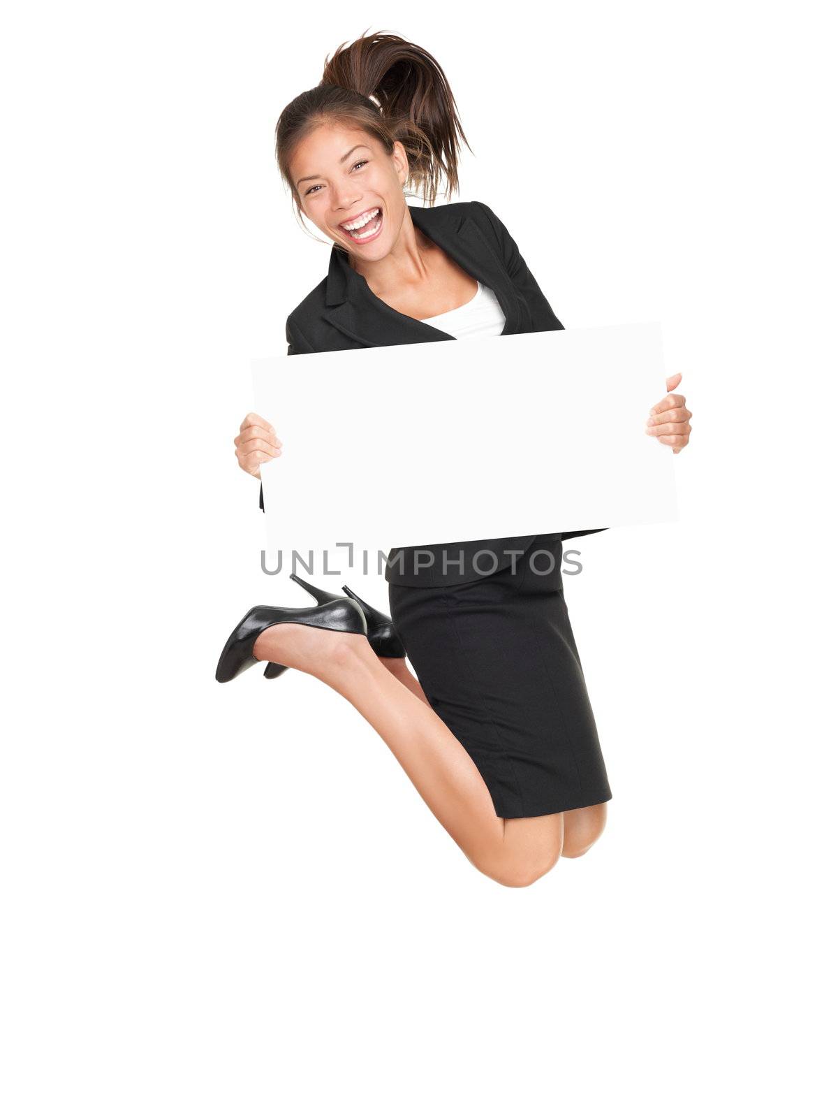 Sign businesswoman jumping happy and excited showing blank empty sign board with copy space for text. Pretty young asian caucasian woman isolated on white background in full length.