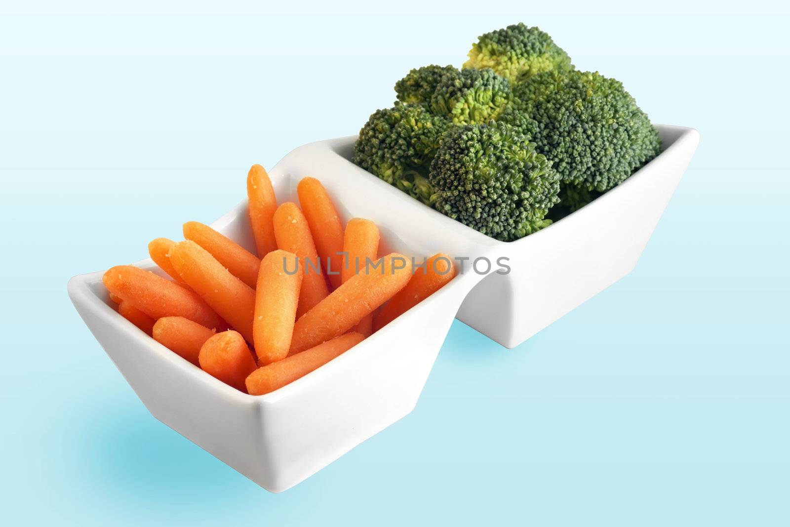 Healthy food choice from the vegetable garden: carrot and broccoli in cute white serving plate.