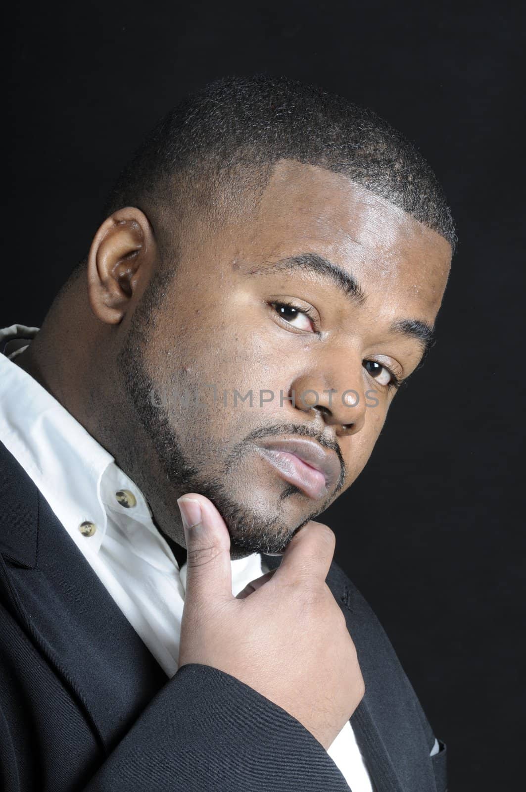 young bearded  African American man in a sports coat and white shirt thinking