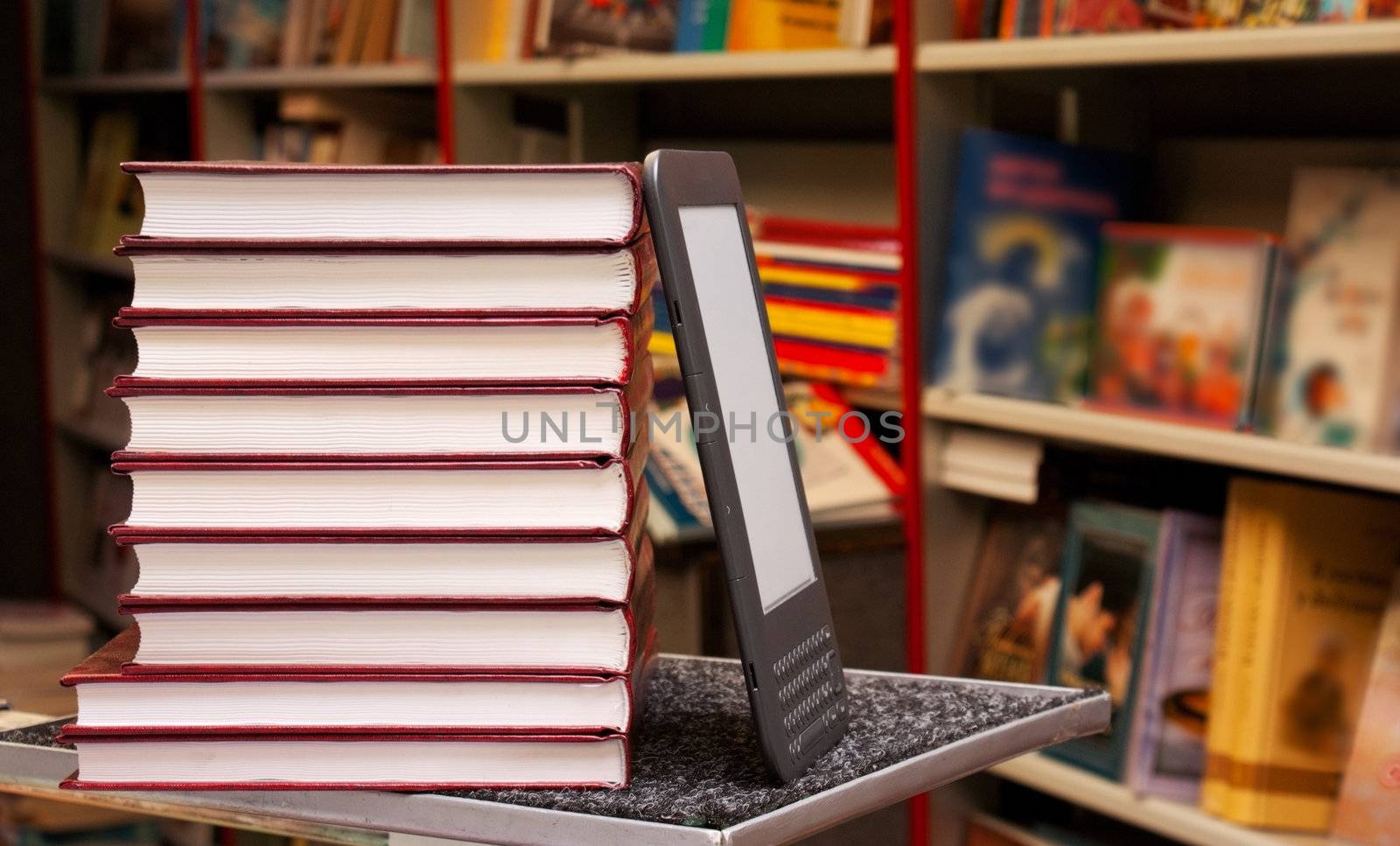 Stack of colorful books with electronic book reader