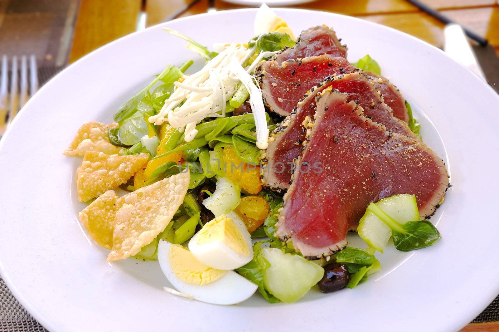 lunch salad with egg, mandarin, salad, sprouts, olives and steak tartar