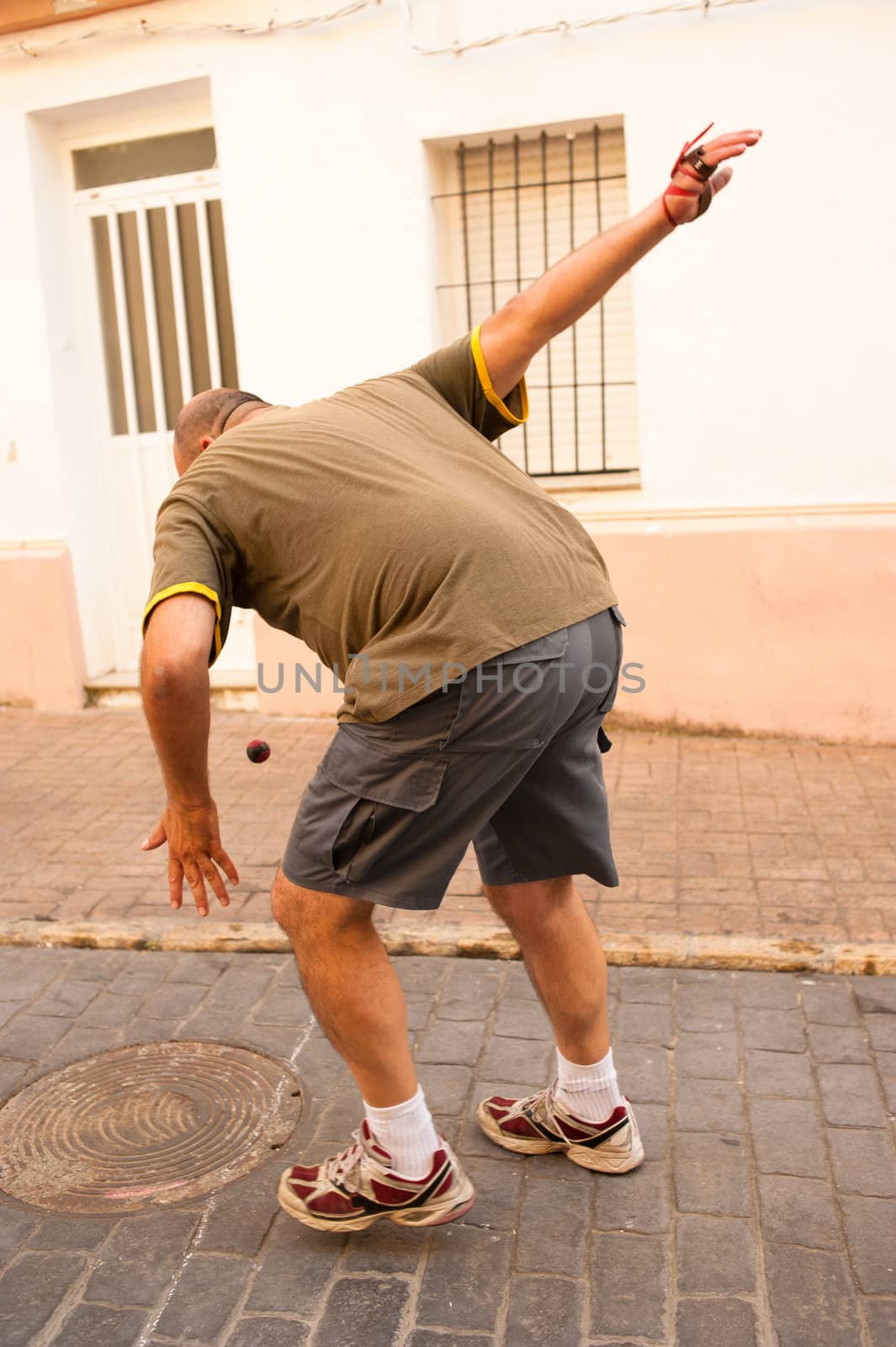 Traditional Spanish pelota player performing a serve