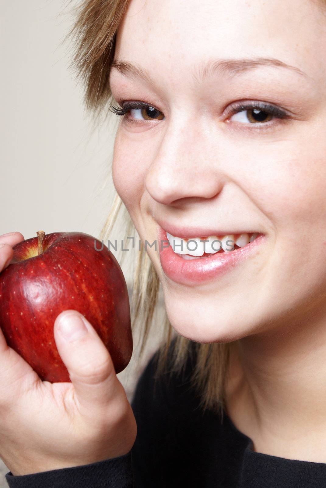 A happy young woman stays healthy by eating some ripe fruit.