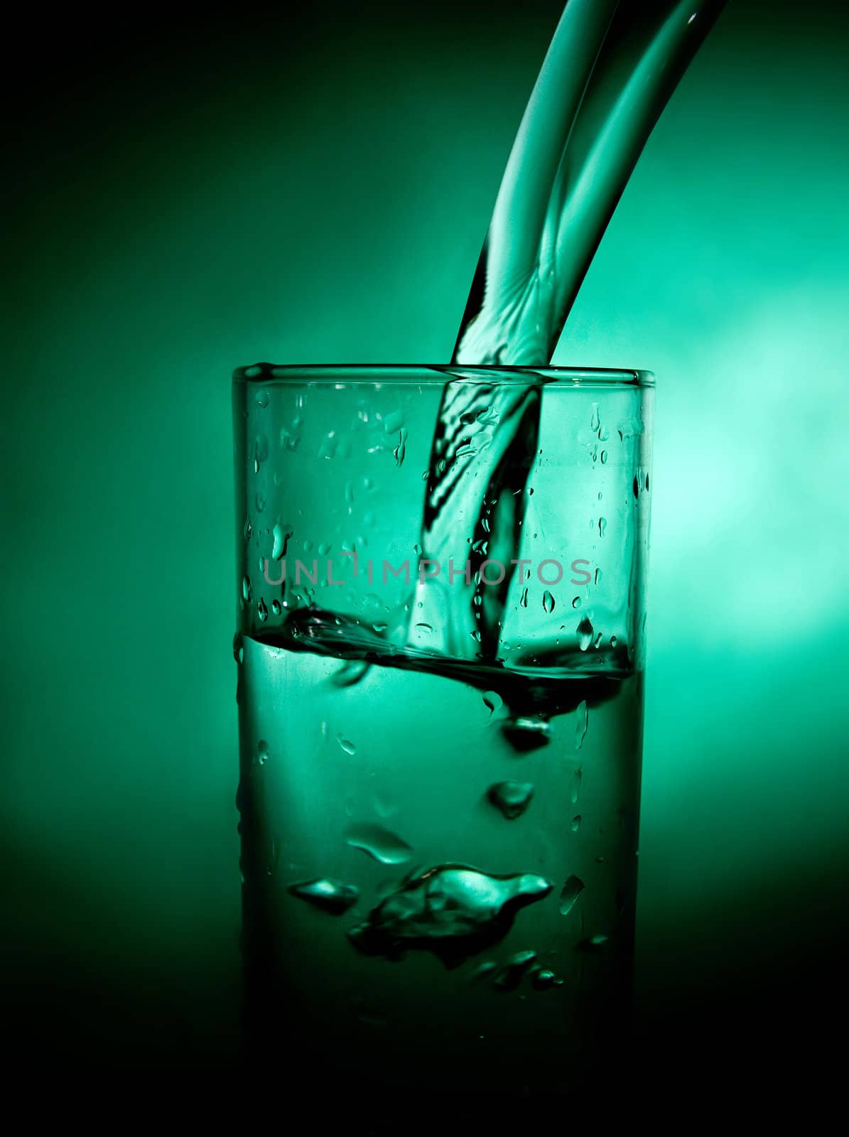 glass beaker with water on a green background