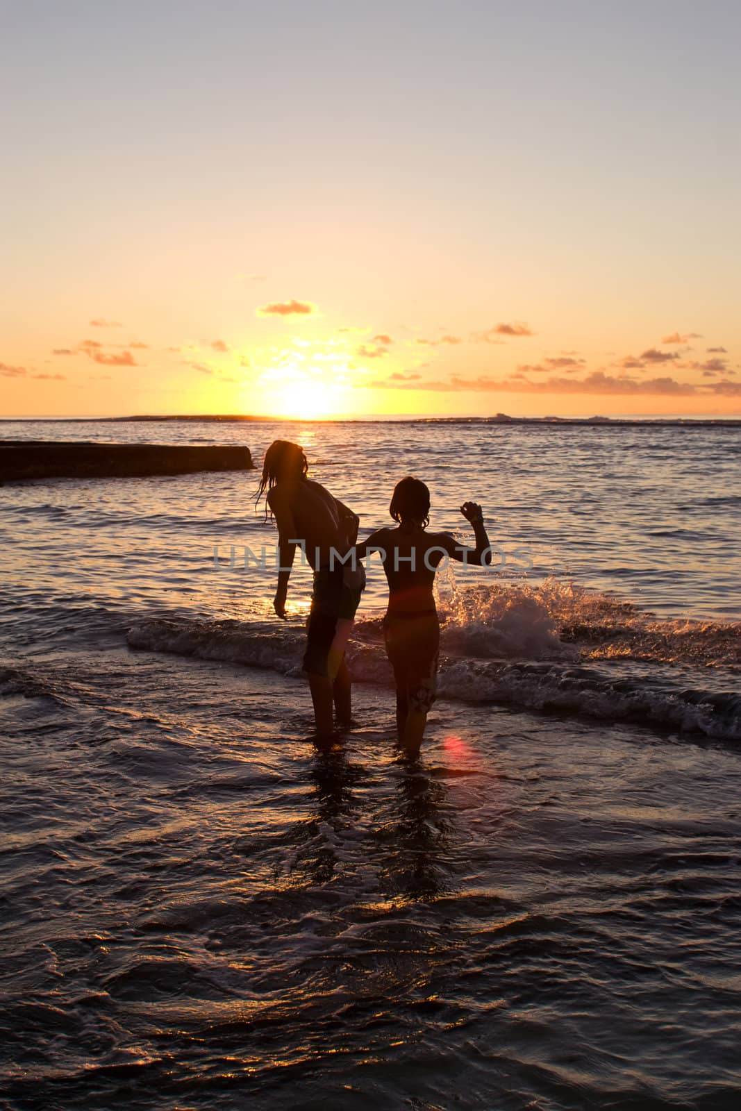 Two young males swim in the waters edge of Ha'atafu Beach, Tonga.