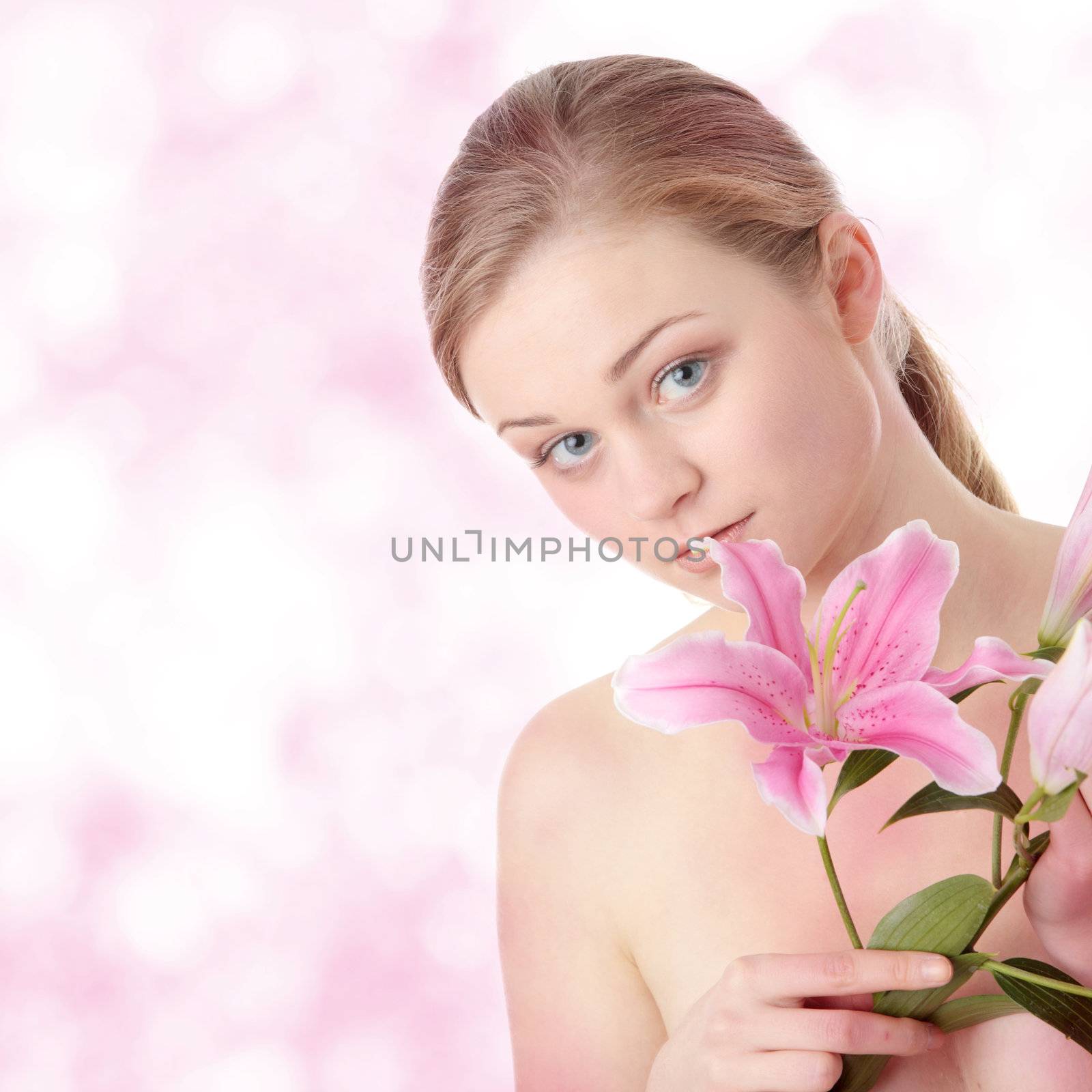 Portrait of young beautiful blond woman with lily flower