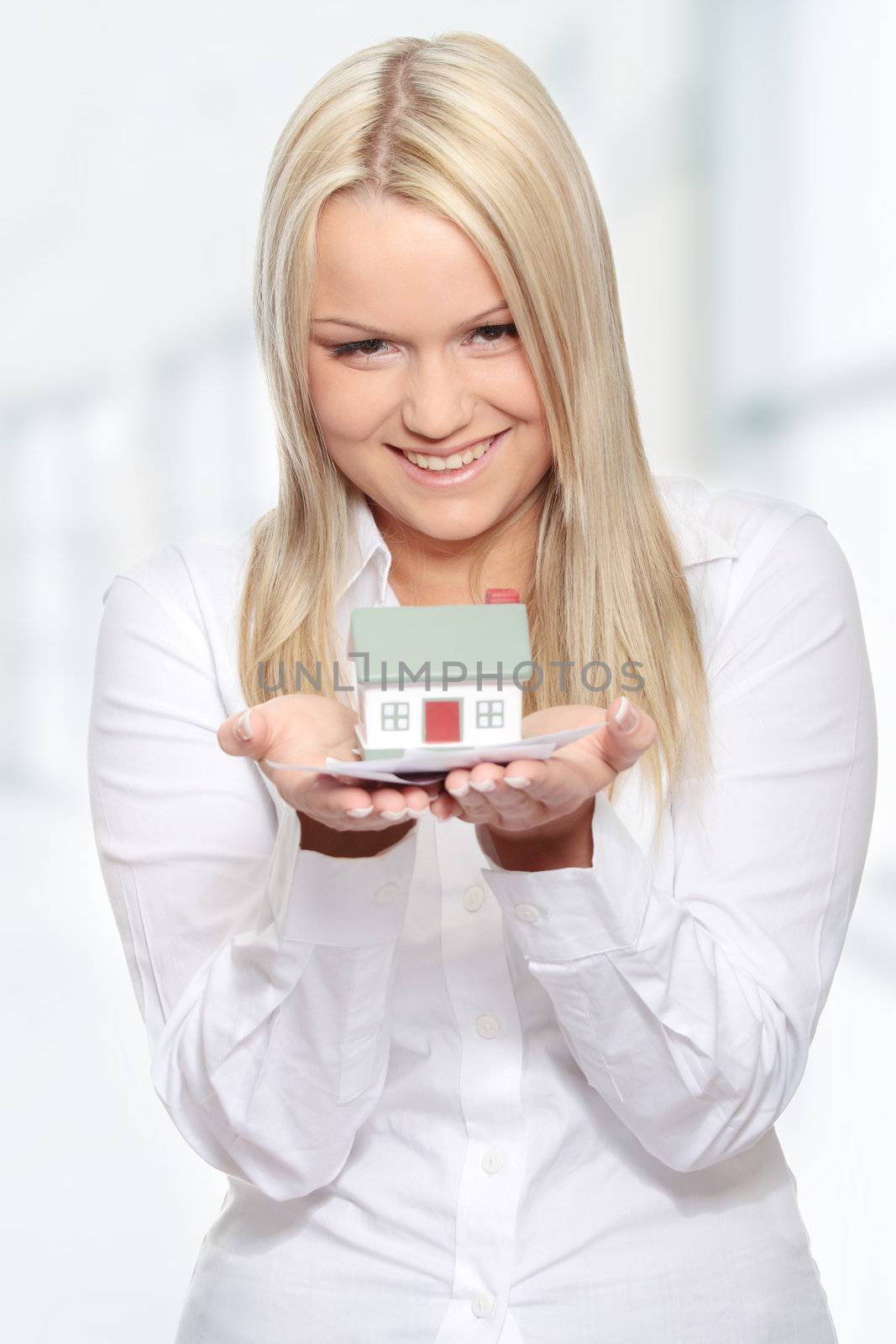 Beautiful young woman holding euros bills and house model over white