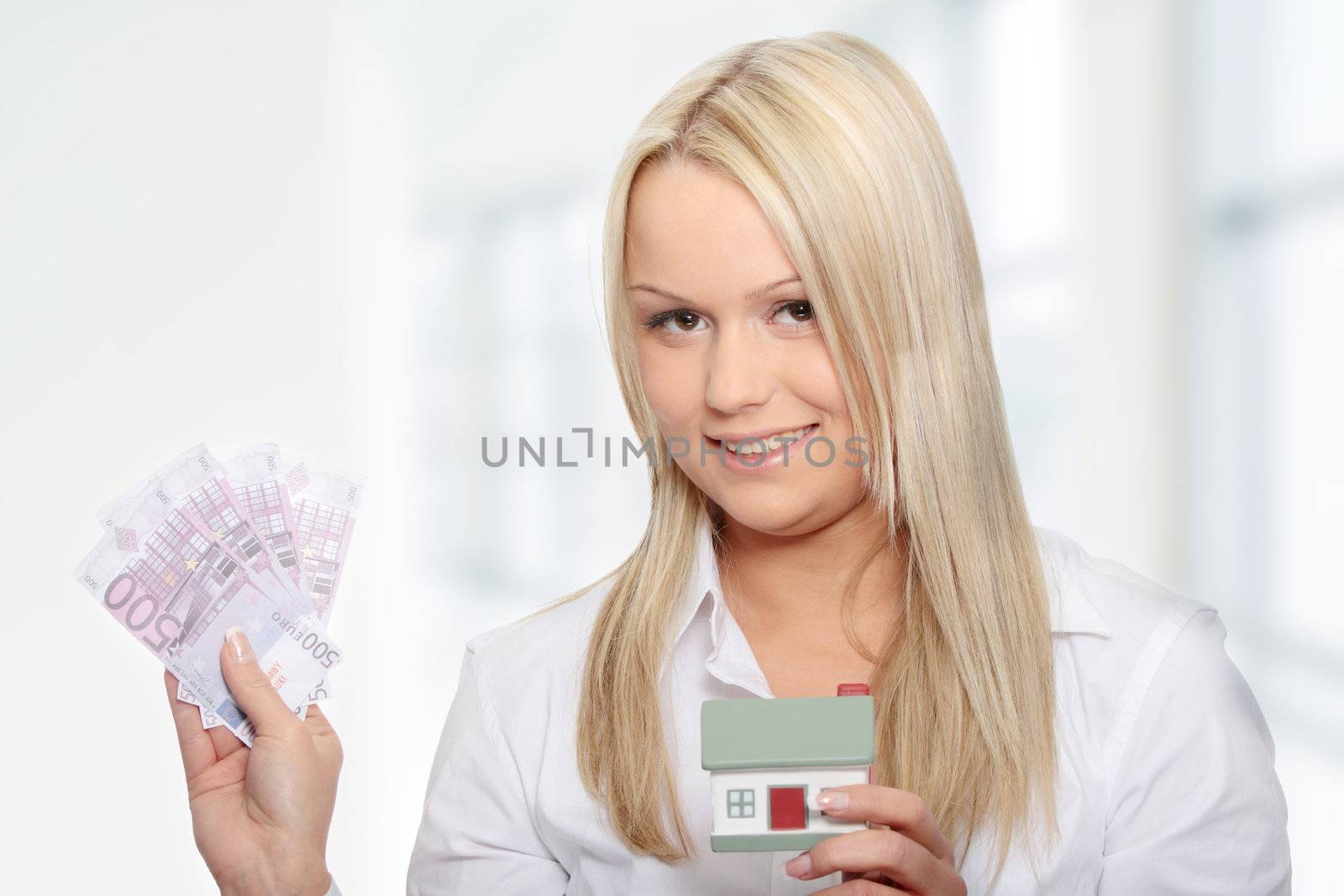 Beautiful young woman holding euros bills and house model over white