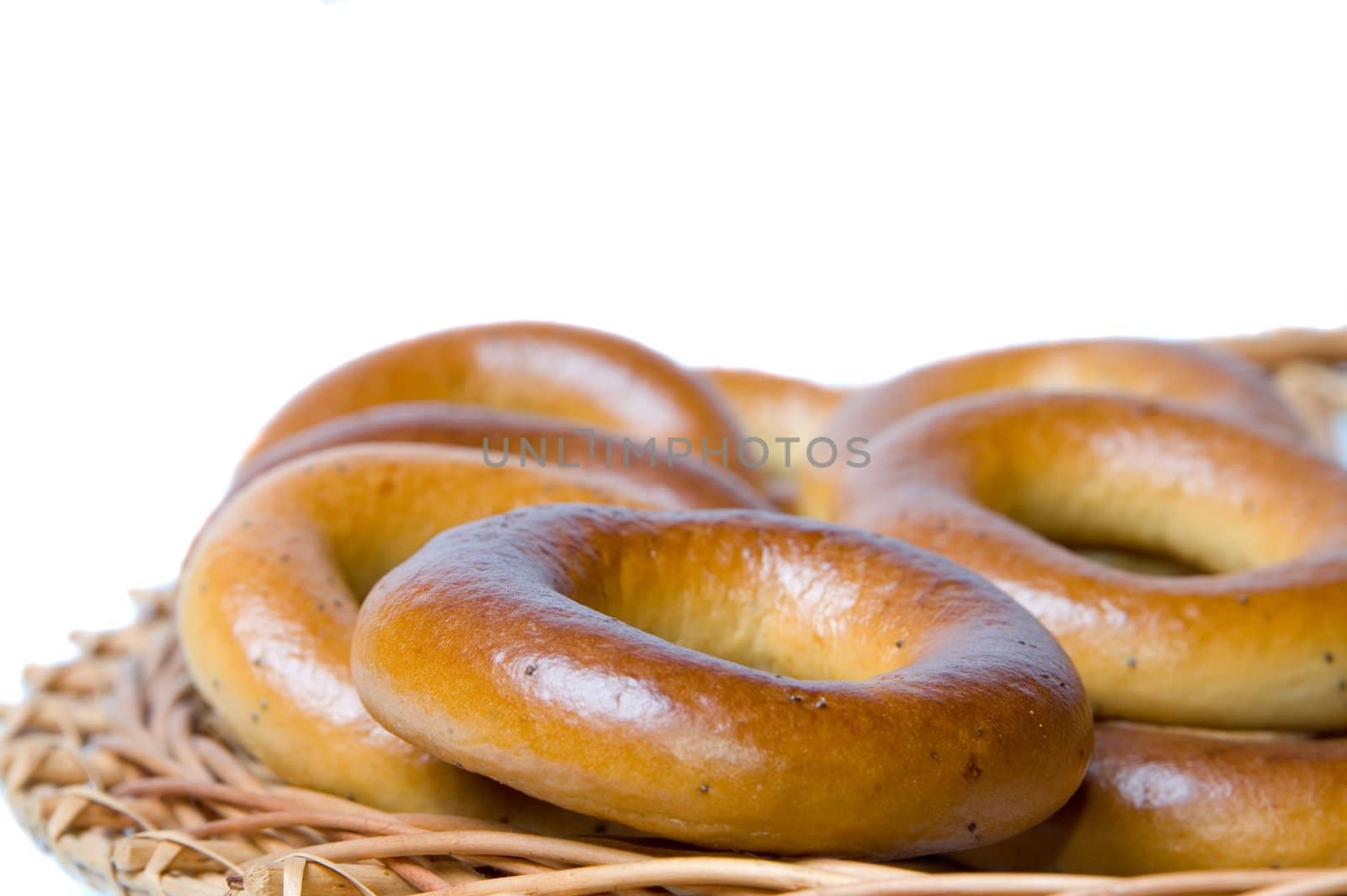 Appetizing bagels on wicker plate at the table