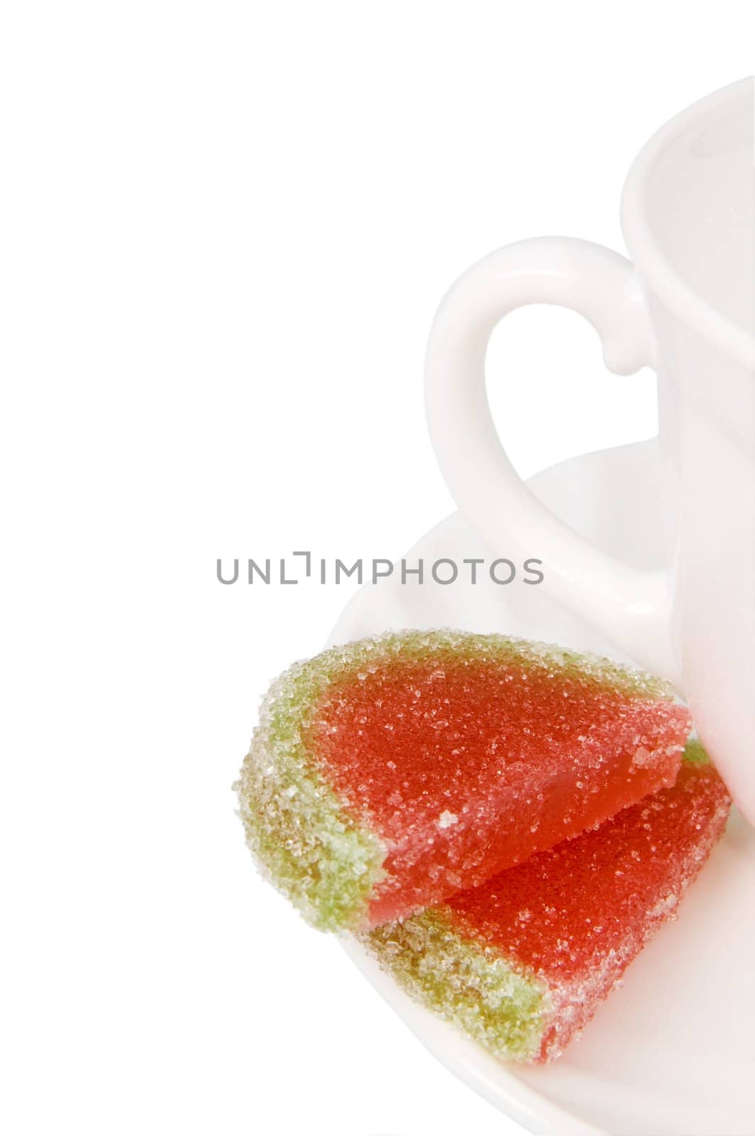 White tea cup and piece of fruit candy