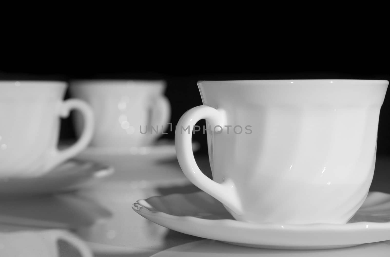 Some white tea cups on a black background