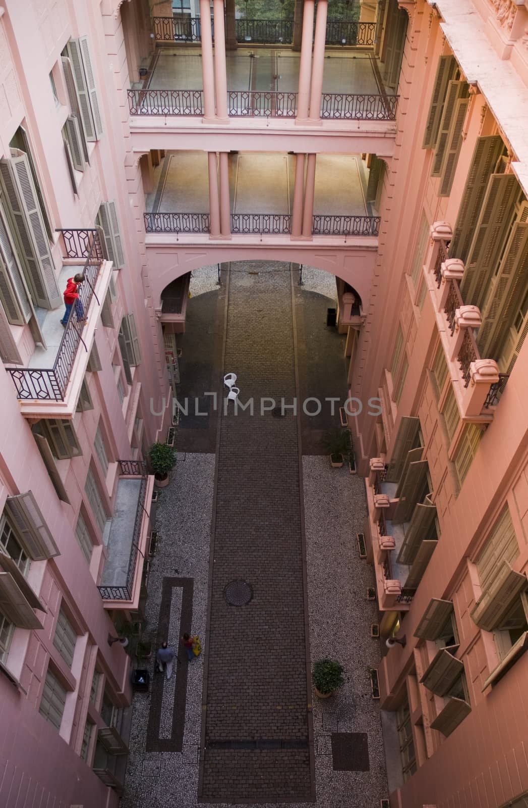 Pink Victorian building shot from a high angle position, showing a street which passes underneath it.