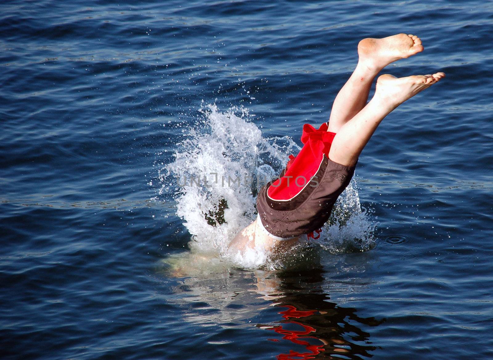 Young boy diving in to the sea.