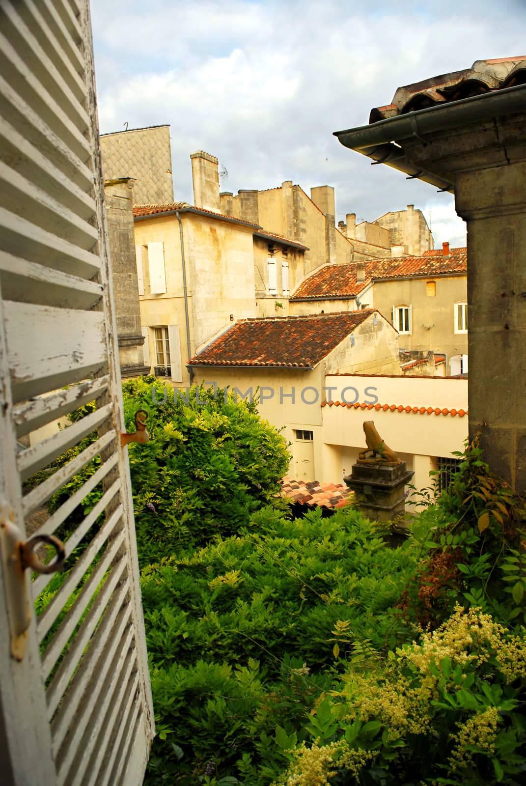 View from an open window with shutters in town of Cognac, France