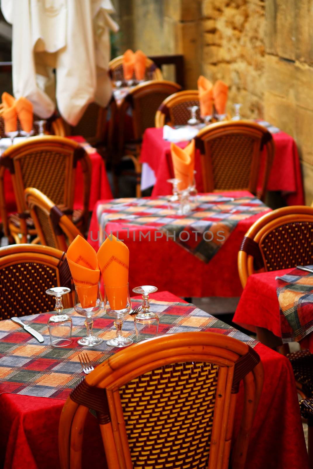 Set tables with tablecloth and glasses on restaurant outdoor patio