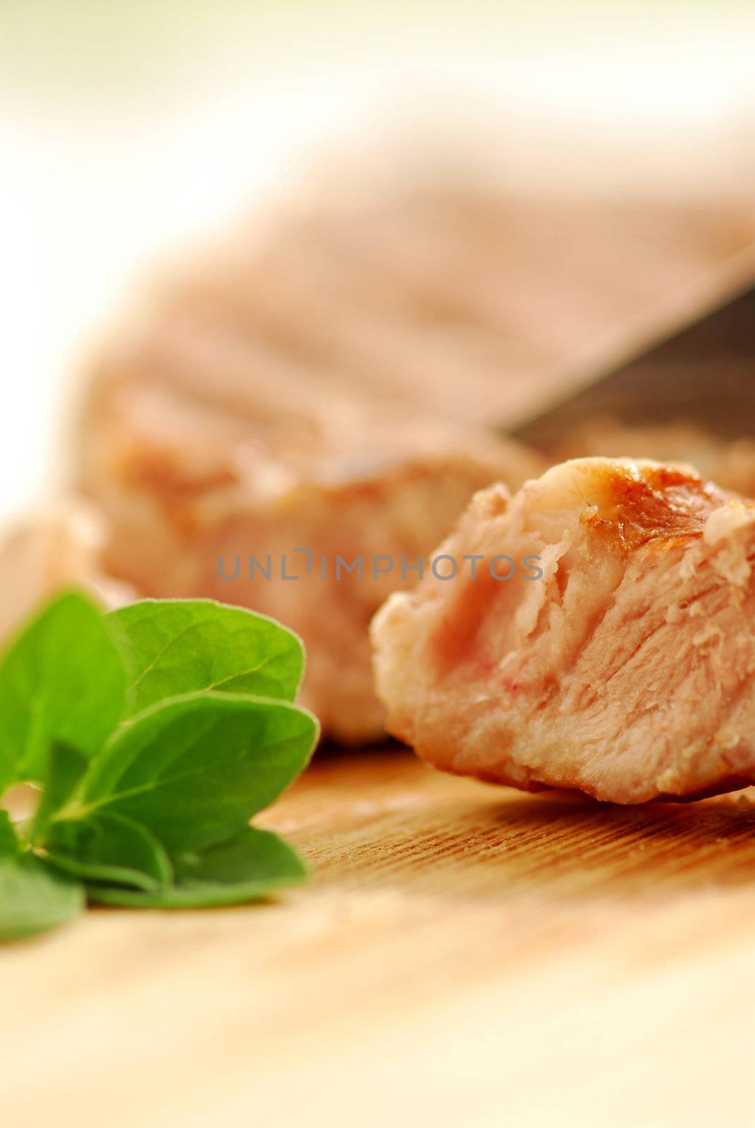 Macro of a grilled steak being cut on a cutting board