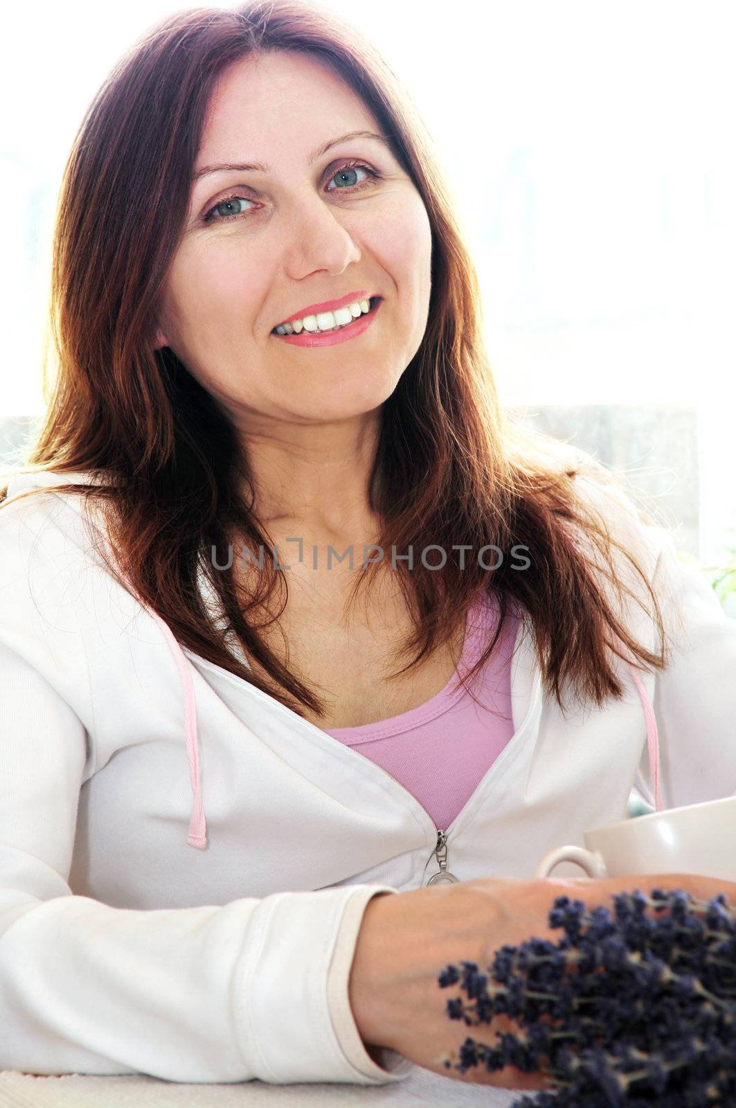 Smiling mature woman relaxing at home holding a cup