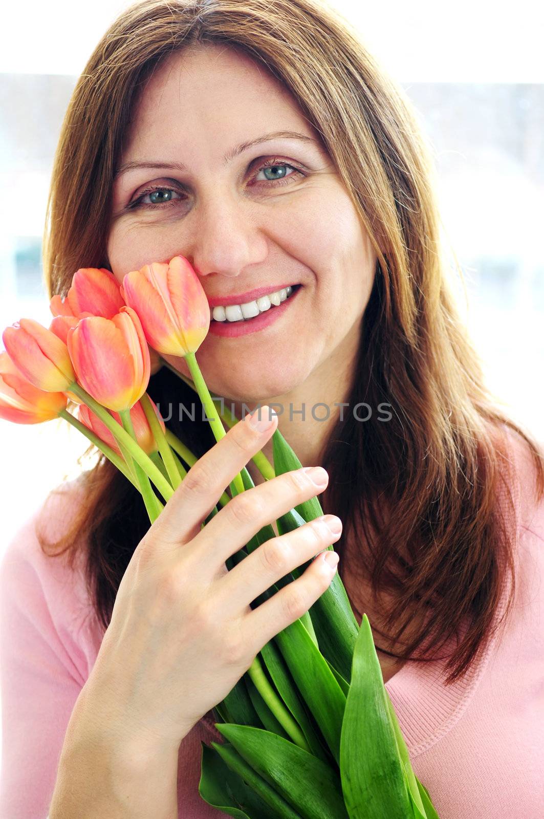 Smiling mature woman holding bouquet of flowers