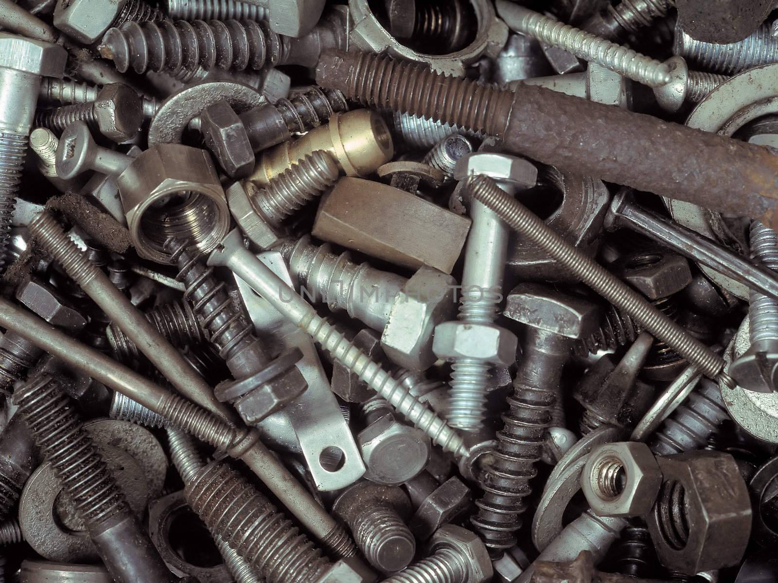 An assortment of bolts, screws, nuts, washers and all kinds of other fasteners piled in a toolbox.
