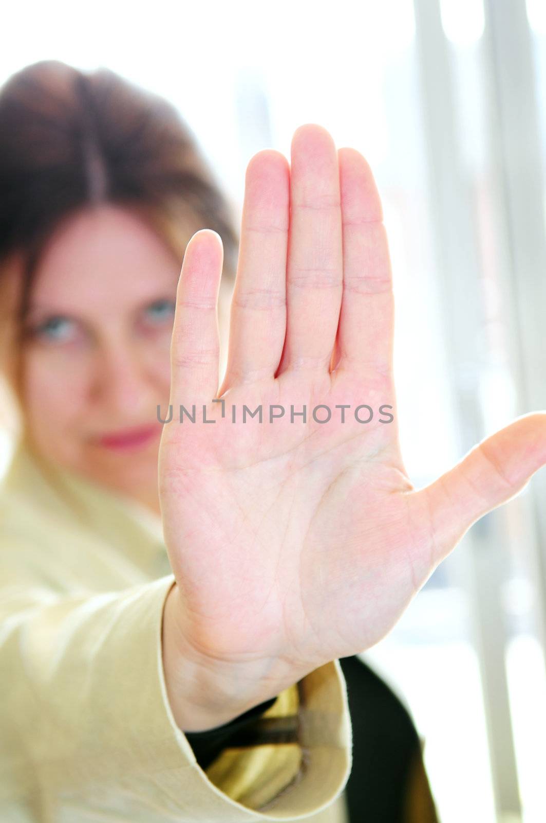 Mature woman gesturing stop with palm of her hand