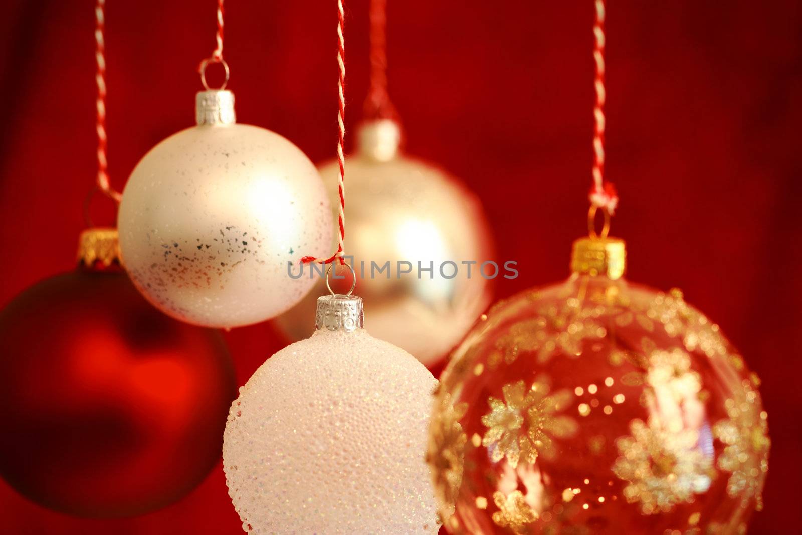 Various Christmas balls hanging with very shallow DOF and selective focus on the hanger of the middle ball.
