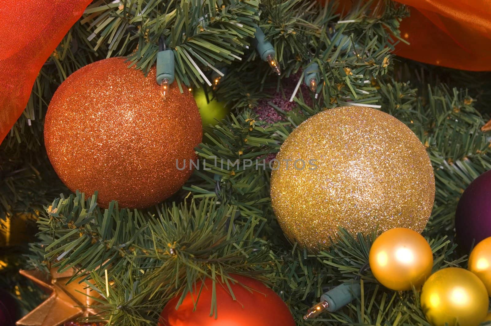 variety of Christmas tree ornaments on an artificial tree also adorned with lights
