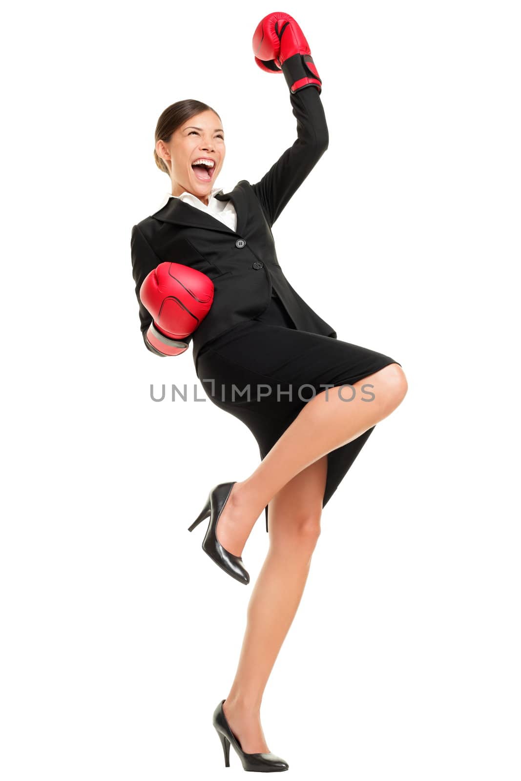 Winning business woman celebrating wearing boxing gloves and business suit. Winner and business success concept photo of young multiracial Asian Caucasian businesswoman isolated on white background.