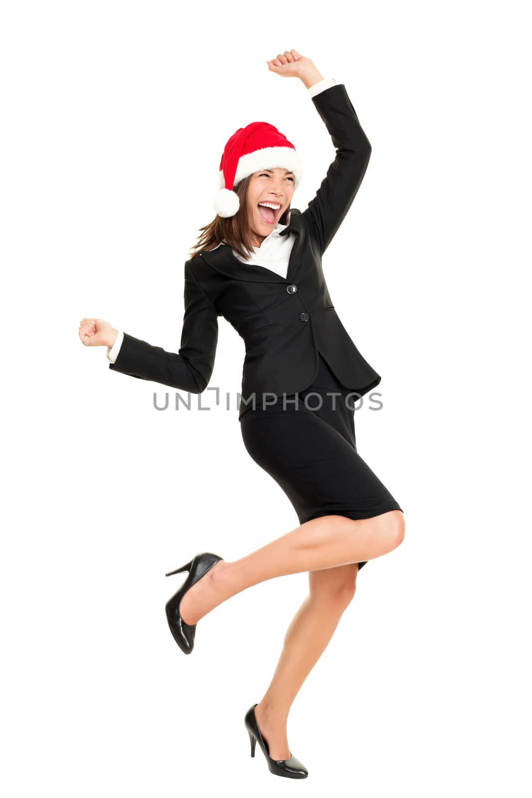 Christmas business woman wearing santa hat dancing happy and excited standing in full body. Beautiful smiling cheerful mixed race Asian Caucasian female businesswoman isolated on white background.