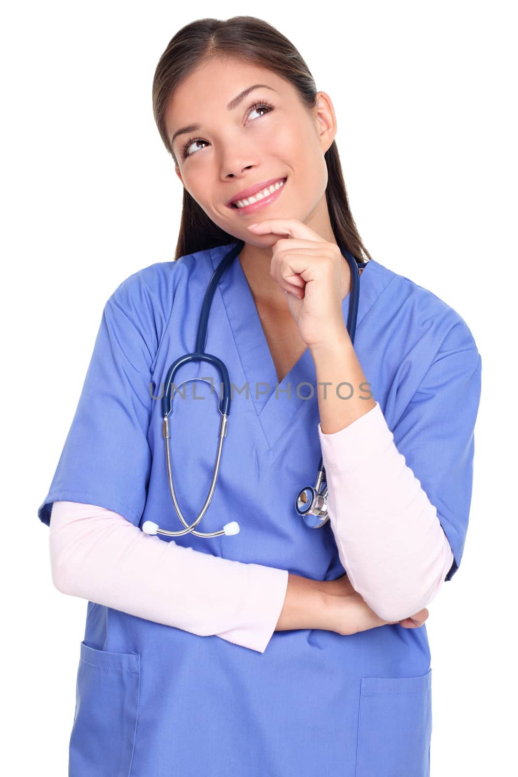 Thinking nurse or medical professional in blue scrubs pondering looking up to the side isolated on white background. Woman model in her twenties.