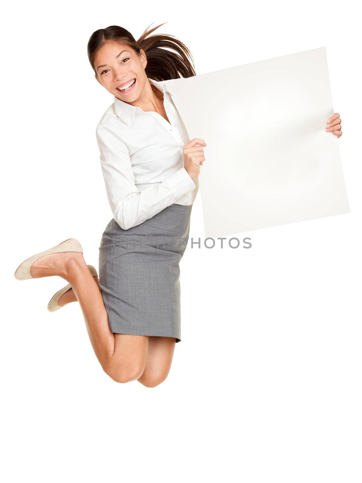 Showing sign. Woman jumping holding poster of paper, blank and empty with copy space. Casual business woman jumping excited smiling happy and cheerful isolated on white background.